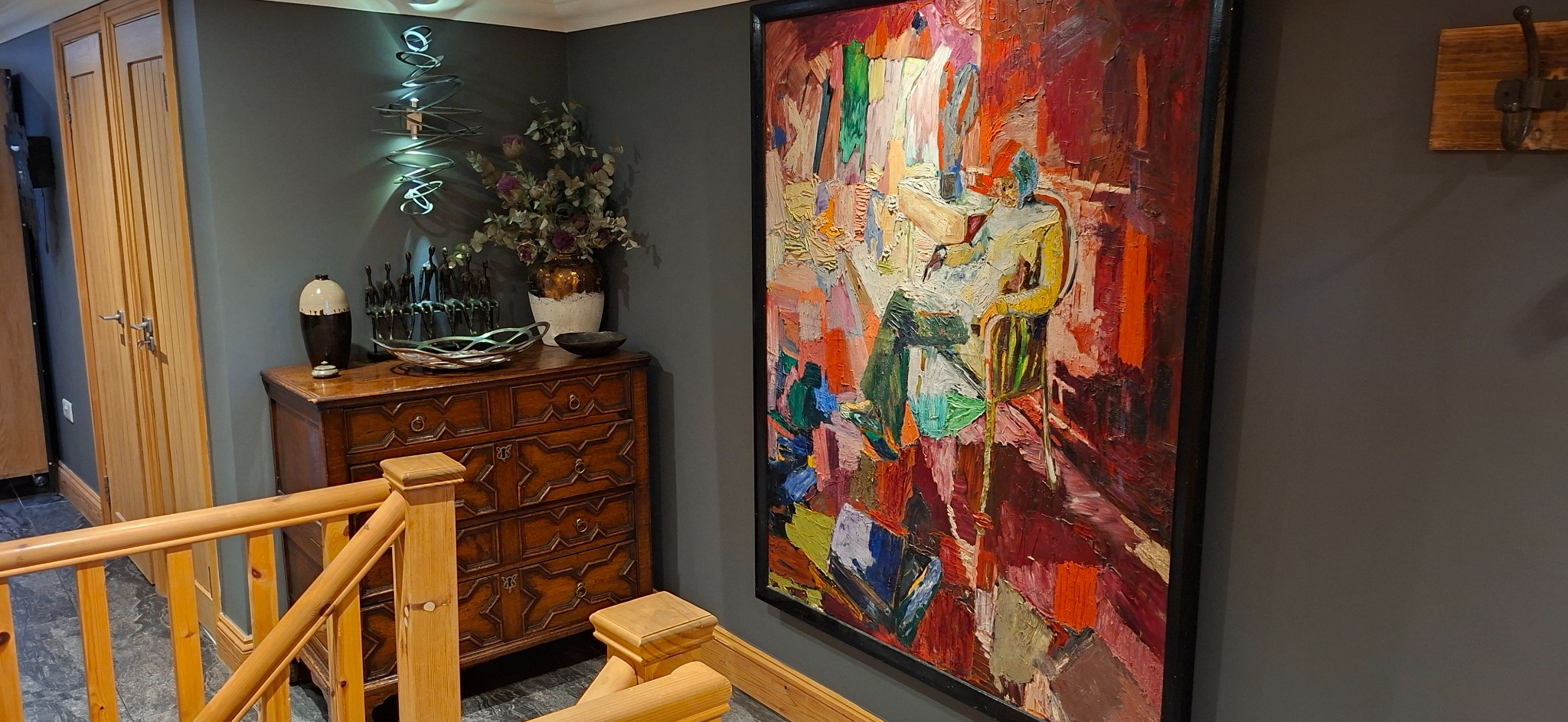 Collected artwork, antique chest, bronze figures and sculptural lighting on the landing