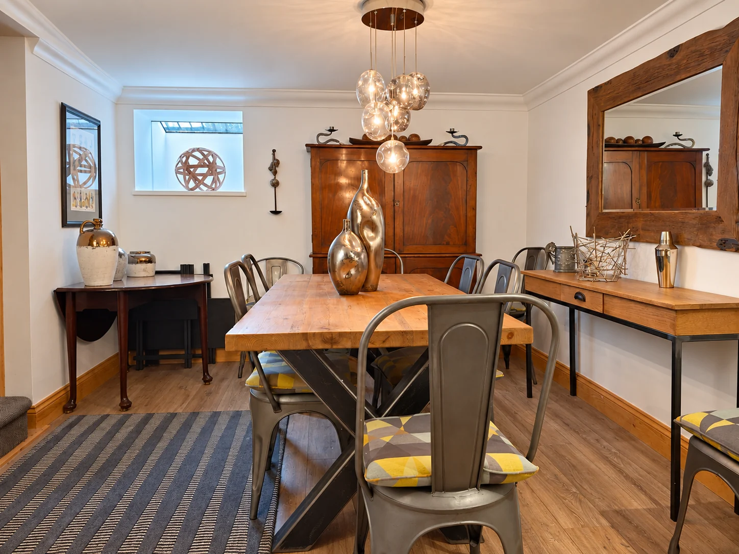 The lower-ground-floor dining room with antique furniture and sculptural lighting